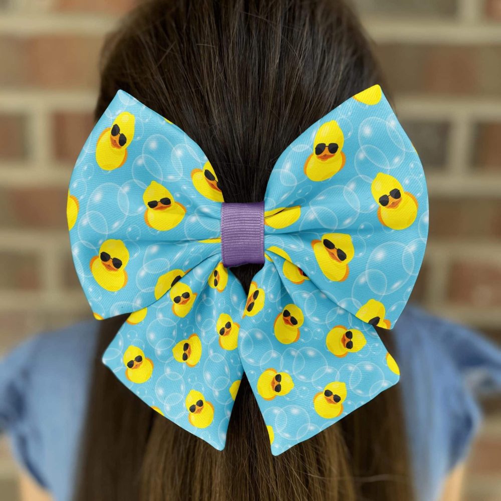 Blue bow with rubber duck pattern on hair.