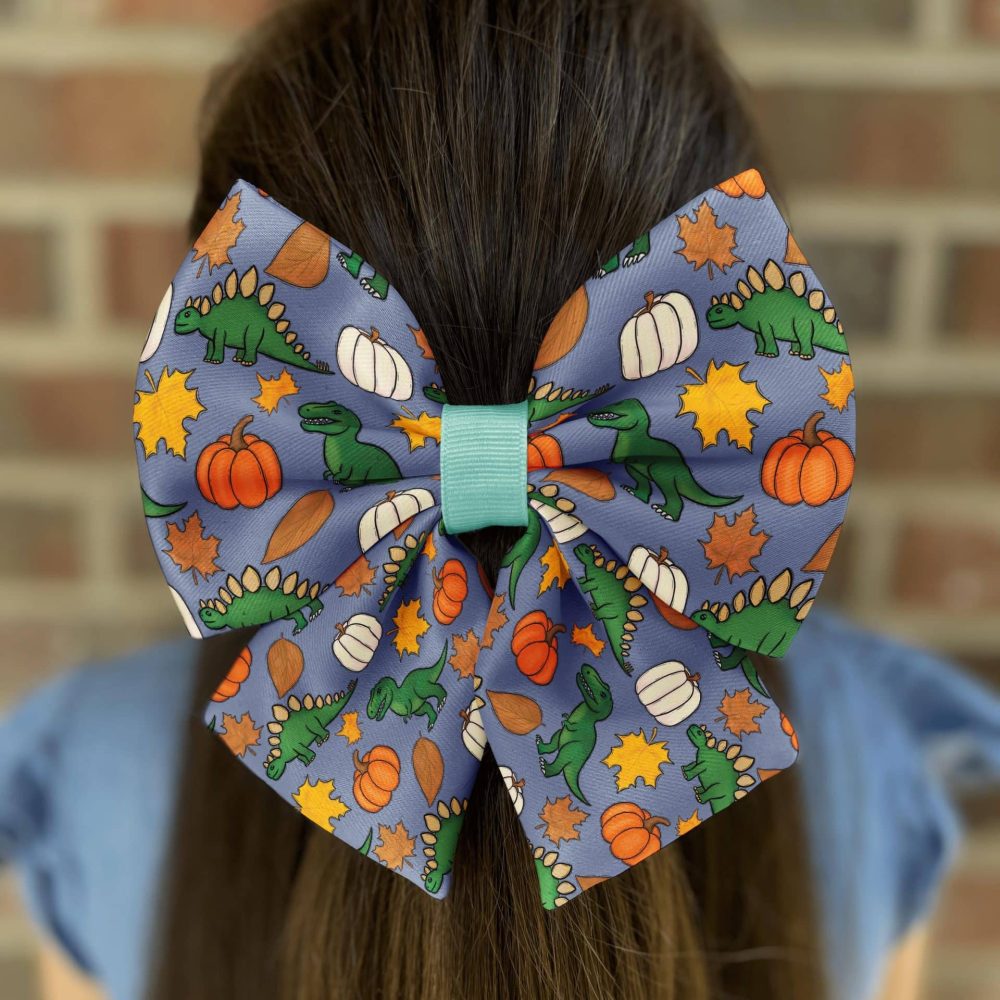 Dinosaur and pumpkin pattern hair bow on girl
