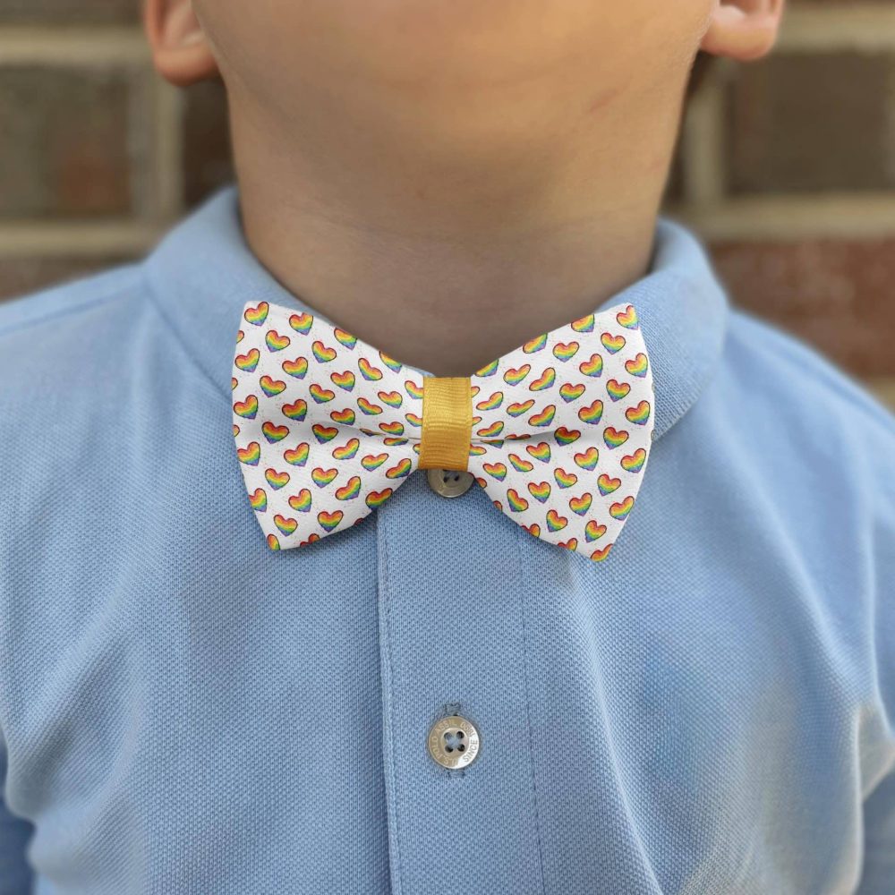 Child wearing blue shirt with heart bow tie