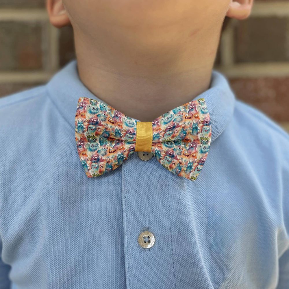 Child wearing a blue shirt with colorful bow tie.