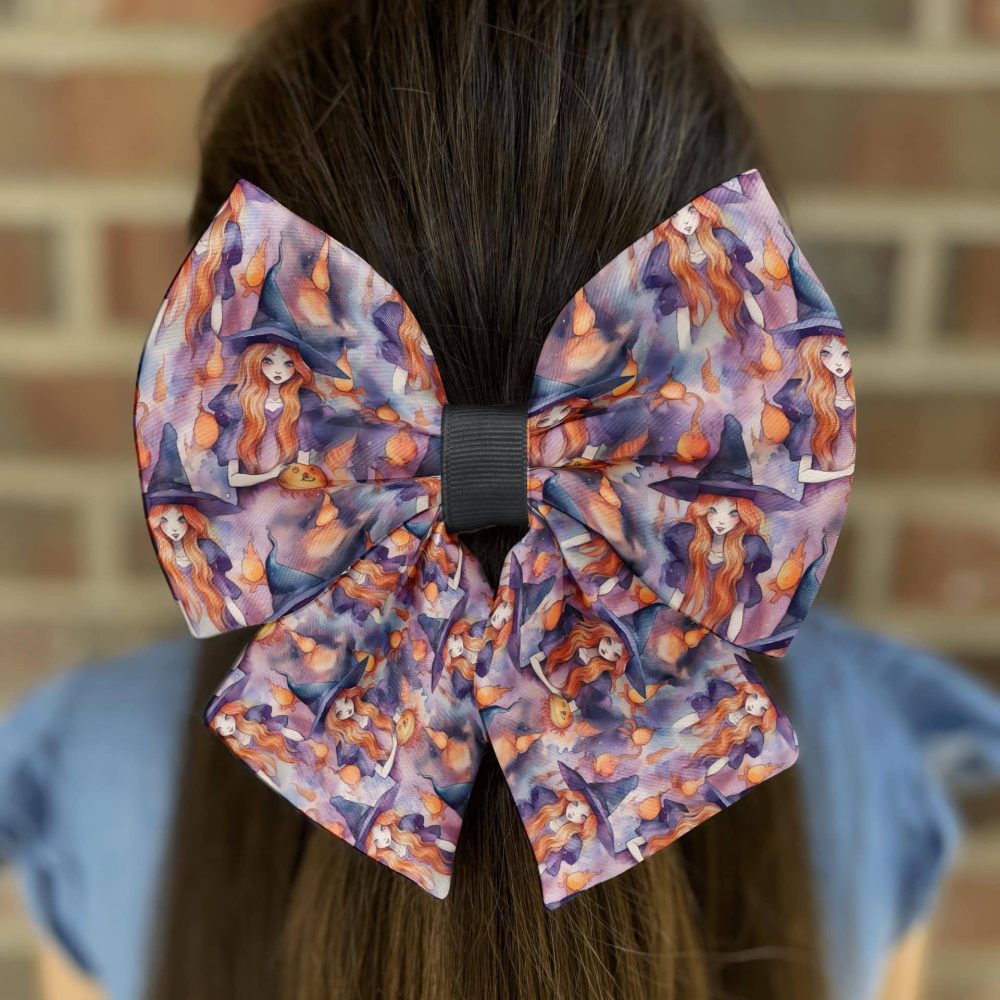 Purple witch-themed bow on dark hair