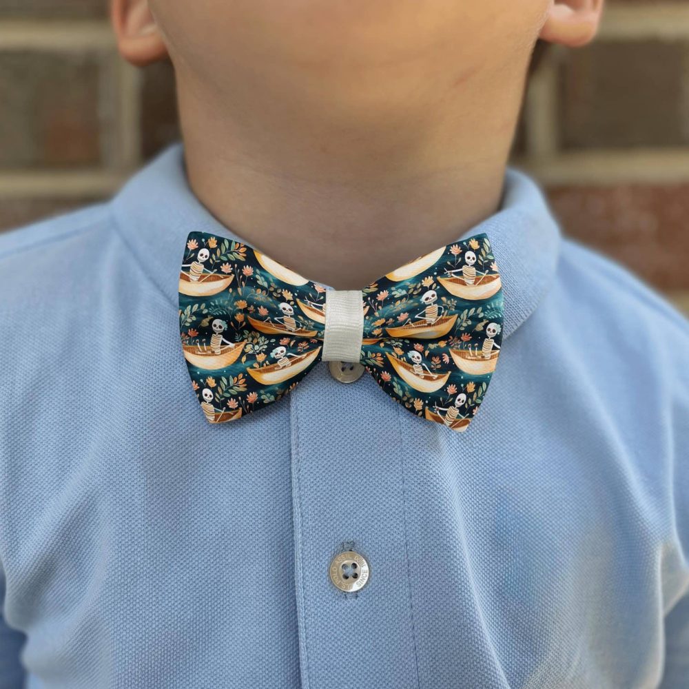 Child wearing blue shirt with skeleton bow tie