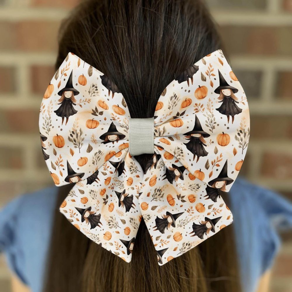 Halloween-themed bow with witches and pumpkins.