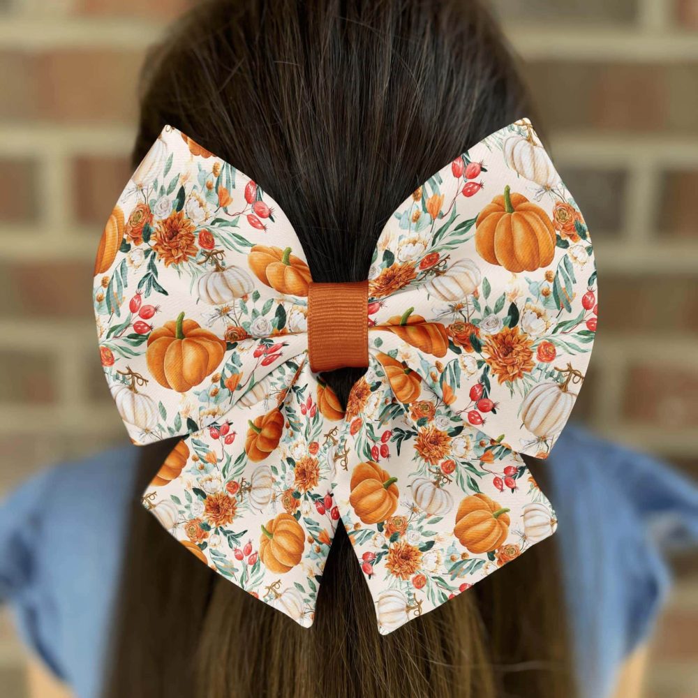 Fall-themed hair bow with pumpkins and flowers.