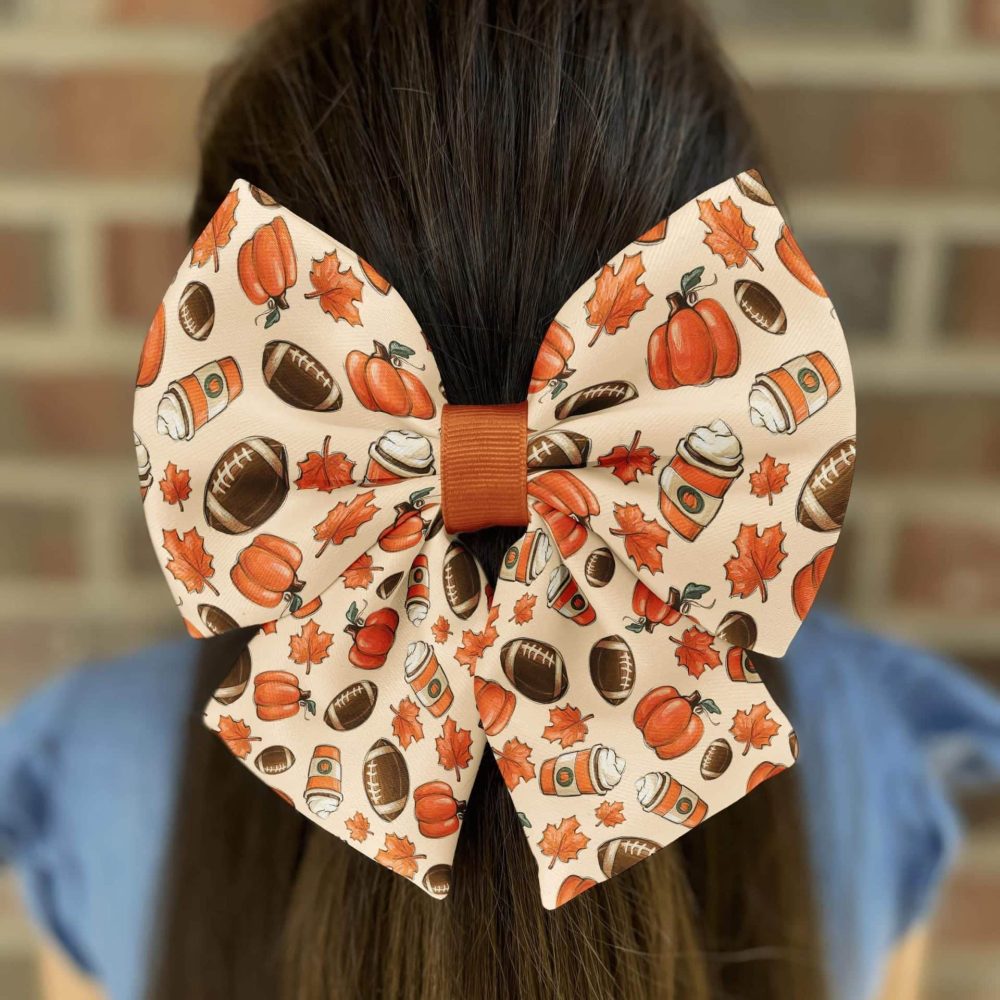 Autumn-themed bow with pumpkins and footballs.