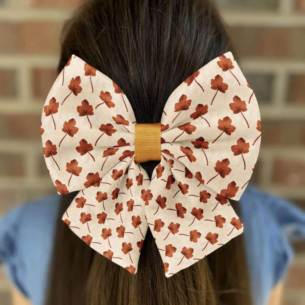Hair with floral-patterned bow on brick background.