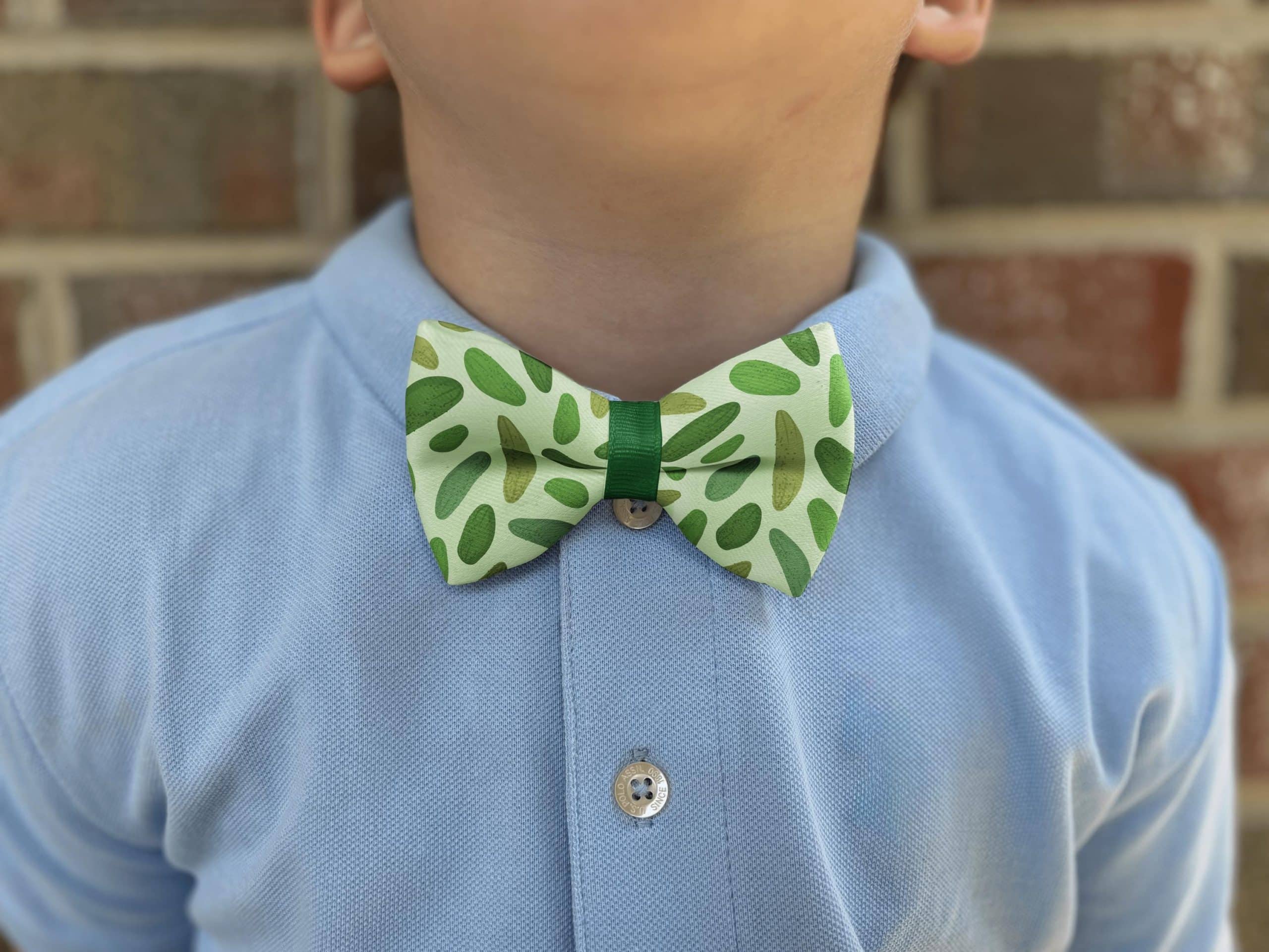 Child wearing green patterned bow tie and blue shirt