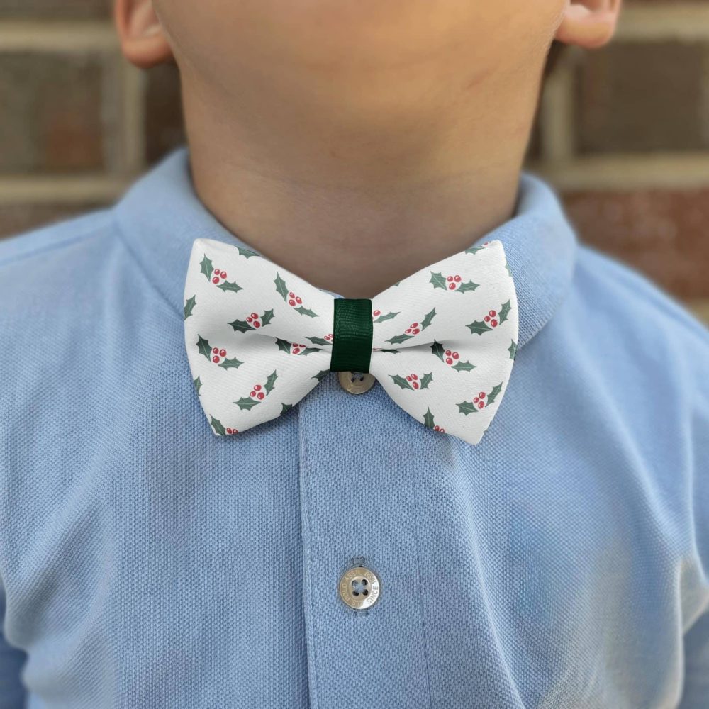 Child wearing holly-pattern bow tie and blue shirt