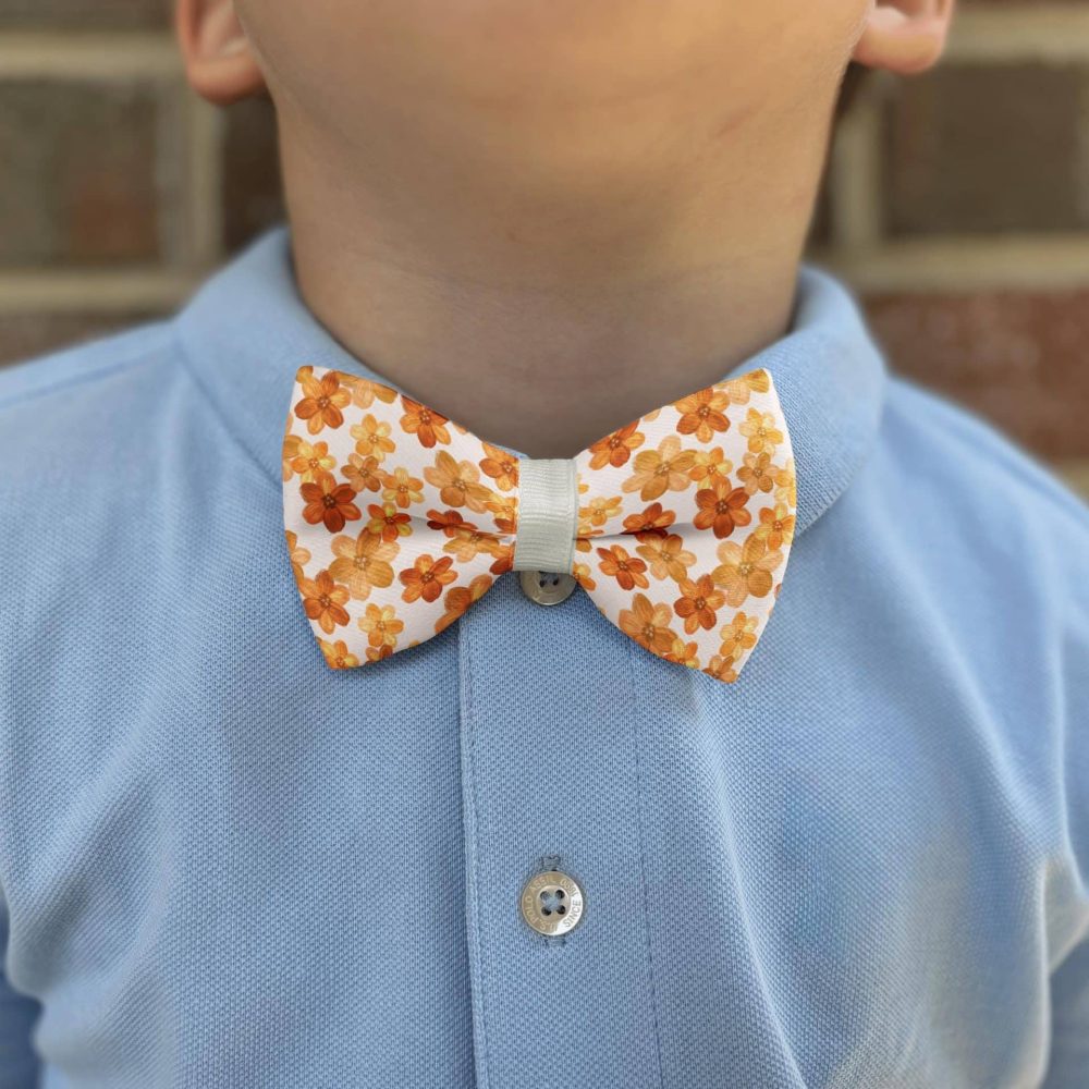 Child wearing blue shirt with floral bow tie.