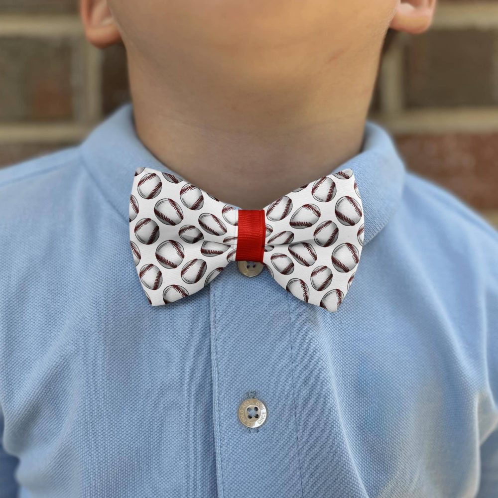 Child wearing football-patterned bow tie and blue shirt.