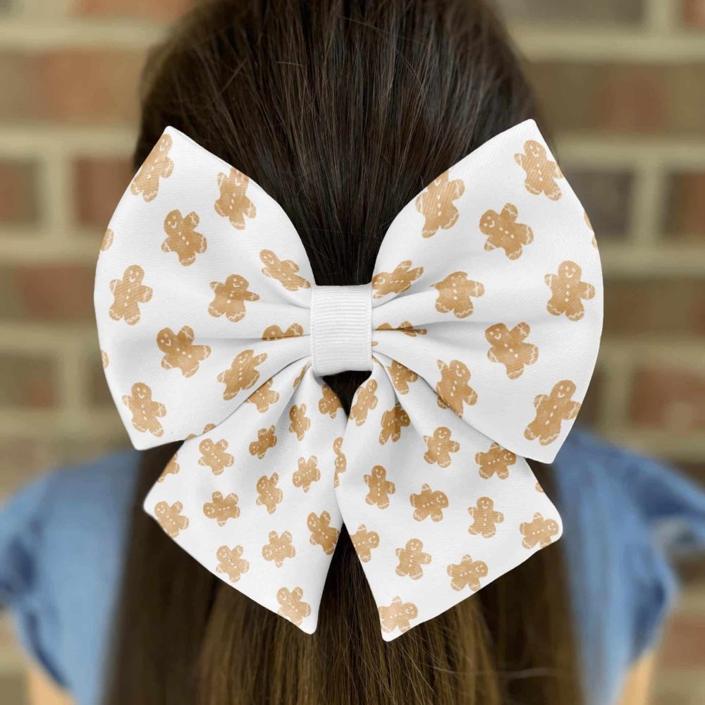 Hair with white gingerbread bow against brick wall.