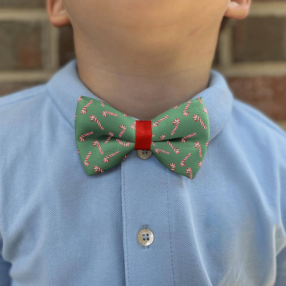 Kid wearing candy cane bow tie and blue shirt.
